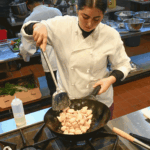 Vêtu d'une blouse de chef blanche, un concurrent de Chop Classic mélange les ingrédients dans un wok. (Photo de courtoisie)