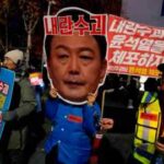 Un manifestant tient une pancarte indiquant : « Arrêtez Yoon Suk Yeol »